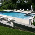 Southampton Magazine shot Patricks Pools custom gunite swimming pool and spa construction. Bluestone patio with stone masonry retaining walls and bench
